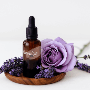 "Lavender cuticle oil with sprigs in a wooden bowl."
